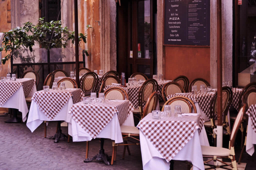 Empty Tables and Chairs in Italian Restaurant by the Street