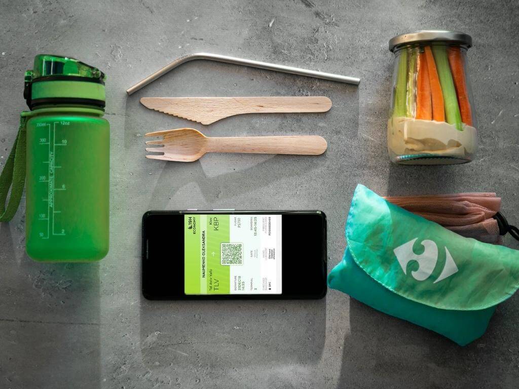 Eco-Friendly Travel Items including a reusable water bottle, metal straw, glass jar, and so on